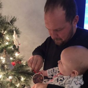 Pittsburgh Photographer JP Diroll and his daughter hang up a Linda Barnicott Christmas ornament on his tree.