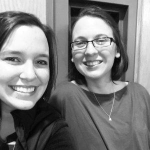 A black and white photo of Alyssa Stadelman (left) and Brittany Barnicott (right), daughters of Linda Barnicott, smiling for the camera.