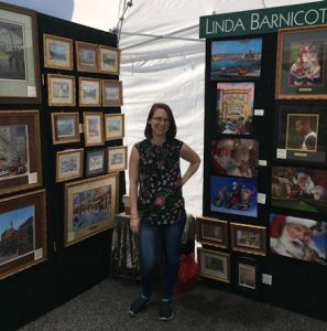 Brittany Barnicott, Linda Barnicott's daughter, poses inside of her booth at the Mt. Lebanon Artists' Market.