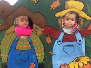 This image shows Abigail and Autumn, granddaughters of Linda Barnicott, in a scarecrow photo station at Trax Farm.