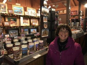 This image shows Linda Barnicott standing in front of her chalet at the Peoples Gas Holiday Market in Market Square, Pittsburgh.