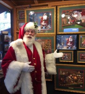 This image shows Santa Claus standing inside Linda Barnicott's chalet at the Peoples Gas Holiday Market in Market Square, Pittsburgh