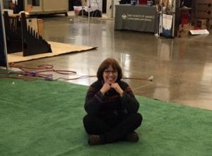 The image is of Linda Barnicott sitting down at the Pittsburgh Home and Garden Show.